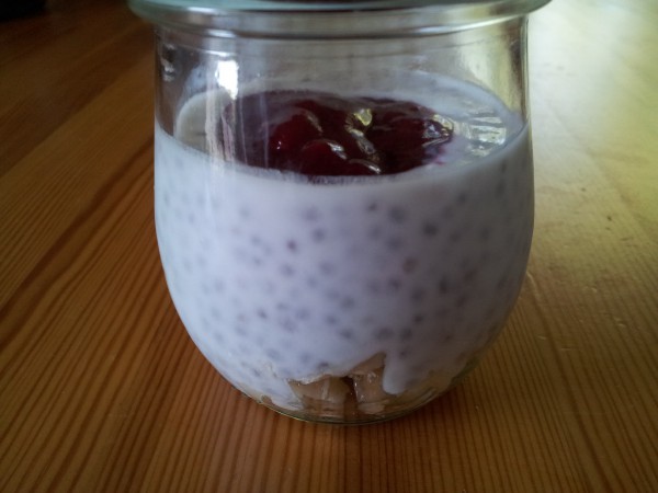 Chia-Pudding mit Joghurt, Banane und Himbeermarmelade.